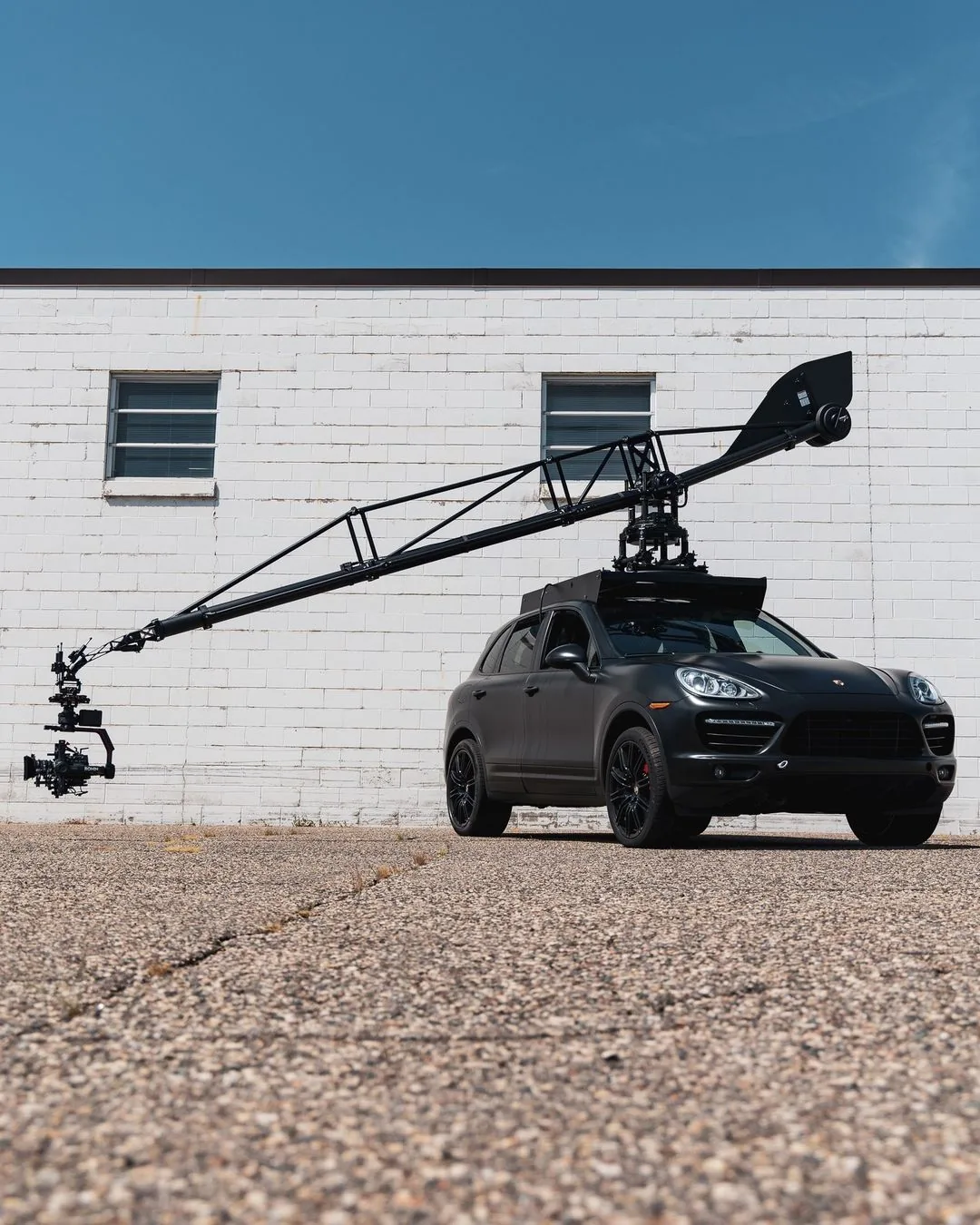 MotoCrane rig mounted on a matte black Porsche Cayenne